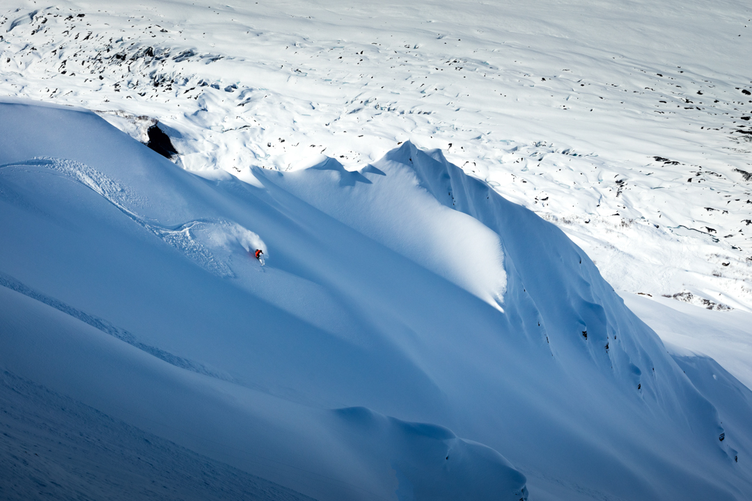 A skier descends a long run in Alaska.