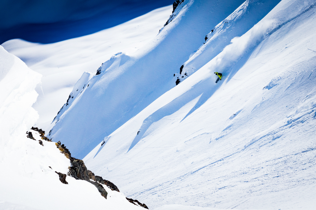Shredding a steep run in Alaska on a snowboard.