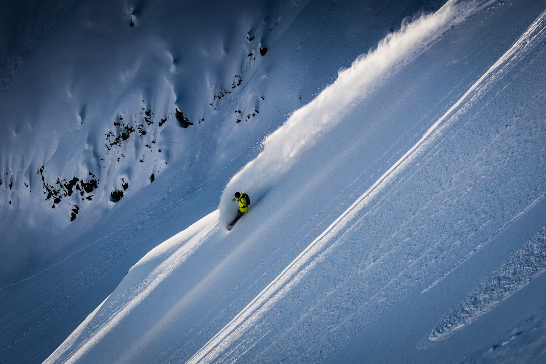 A snowboarder makes a steep turn in Alaska.
