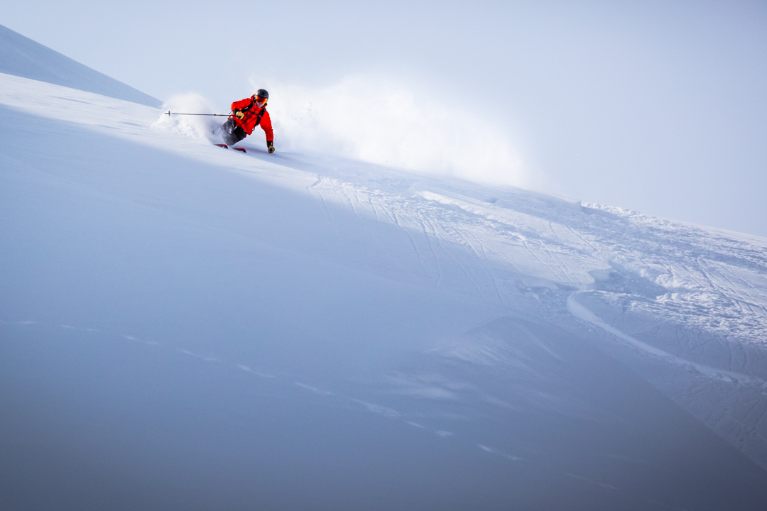 Skier carving through powder in Alaska.