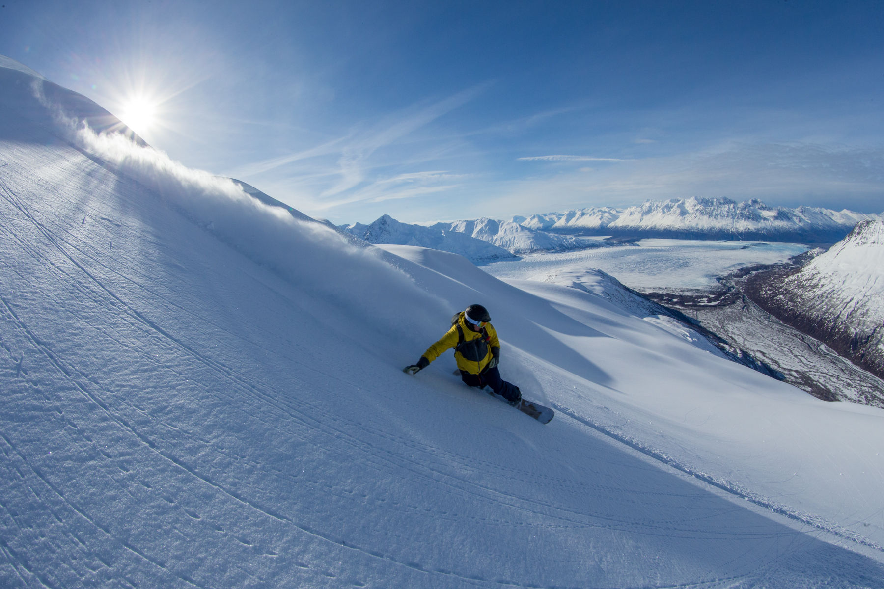 A snowboarder arcs a perfect turn in untouched powder.